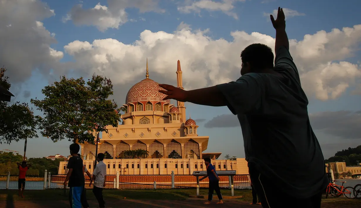 Anak-anak bermain di halaman masjid berwarna pink, kawasan Putrajaya, Malaysia. Gaya arsitektur Masjid Pink ini terilhami dari konsep masjid-masjid di Turki dan Timur Tengah yang berpadu dengan arsitektur Melayu. (File, AP Photo/Joshua Paul)
