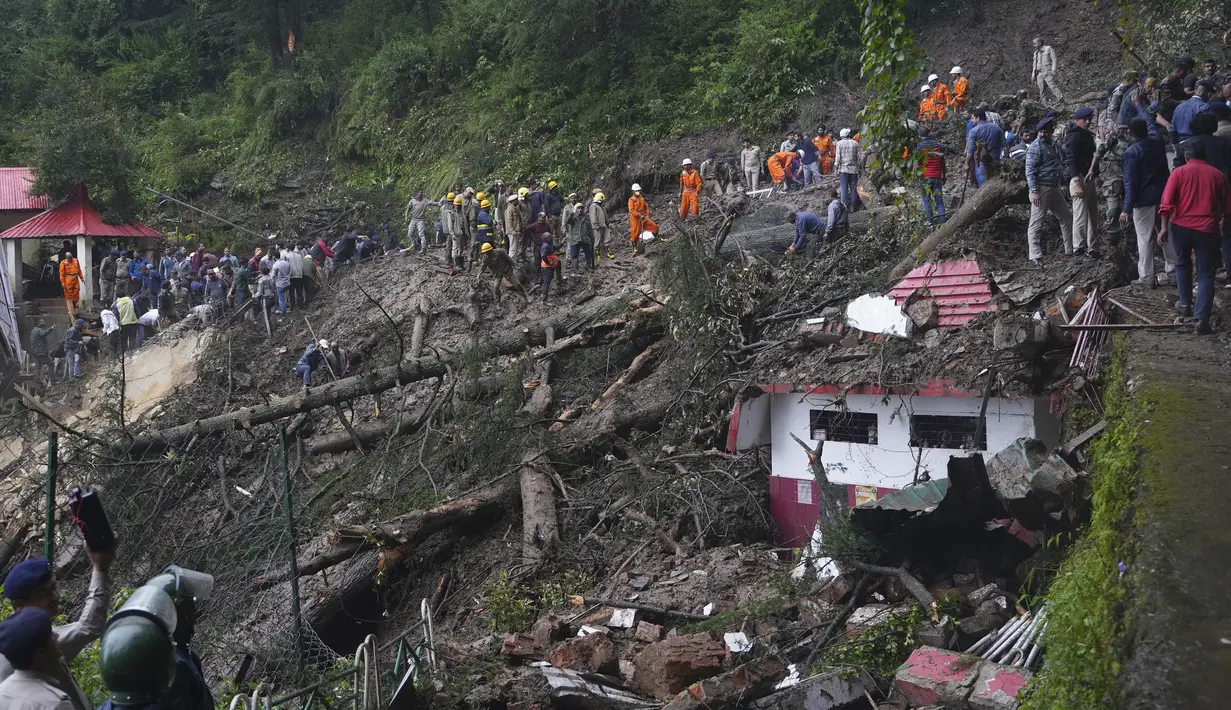 Tim penyelamat membersihkan lumpur dan puing-puing saat mereka mencari orang-orang yang dikhawatirkan terjebak setelah tanah longsor di dekat sebuah kuil di pinggiran Shimla, negara bagian Himachal Pradesh, Senin, 14 Agustus 2023. (AP Photo/Pradeep Kumar)