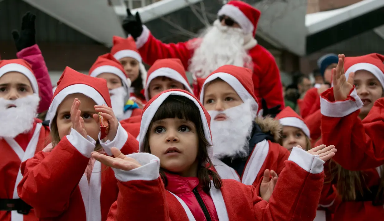 Anak-anak berpakaian seperti Sinterklas mengambil bagian dalam Santa Claus Run di Pristina, Kosovo, Minggu (16/12). Ratusan pelari berpartisipasi dalam lomba lari amal untuk menggalang dana bagi keluarga yang membutuhkan di Kosovo. (AP/Visar Kryeziu)