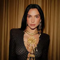 Gaun berpotongan v-neck rendah yang dipadu dengan kalung emas siluet emas bergaya Aztec [@dualipa]