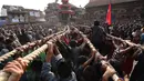 Umat Hindu Nepal menarik kereta kayu dewa Bhairava yang melewati kerumunan saat festival Bisket Jatra di Bhaktapur, Nepal (10/4). Festival ini diadakan untuk menandai Tahun Baru Nepal. (AFP Photo/Prakash Mathema)