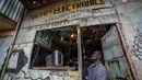 Seorang pria menonton berita pemilu di televisi di sebuah bengkel elektronik di daerah Kibera, Nairobi, Kenya, Kamis, 11 Agustus 2022. Rakyat Kenya menunggu hasil pemilihan presiden yang berlangsung ketat namun tenang di mana jumlah pemilih lebih rendah daripada biasanya. (AP Photo/Ben Curtis)