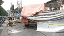 Garis polisi terpasang dekat bangkai truk tangki yang terbakar di SPBU Jalan Kahfi 2, Jagakarsa, Jakarta, Sabtu (30/12). Saat terbakar, truk yang kini ditutup terpal oranye itu diketahui memuat bahan bakar jenis pertalite. (Liputan6.com/Herman Zakharia)