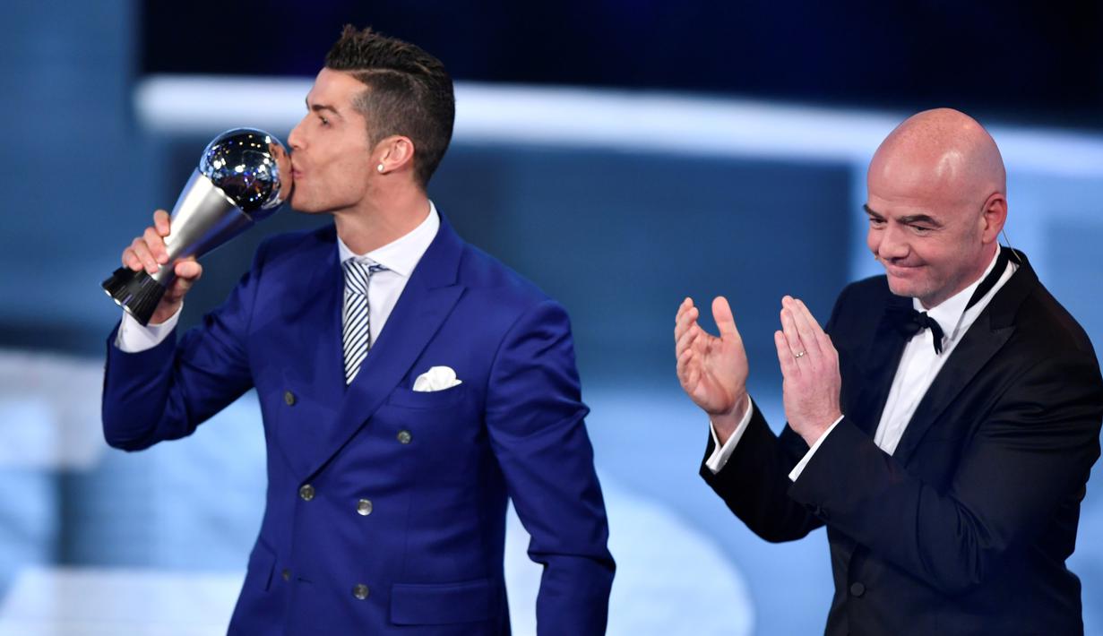 Cristiano Ronaldo saat mencium The Best FIFA Men's Player of 2016 Award yang diberikan Presiden FIFA Gianni Infantino pada ajang The Best FIFA Football Awards 2016  di Zurich, (9/1/2017). (AFP/Fabrice Coffrini)
