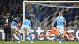 Kiper AC Milan, Mike Maignan, sukses menggagalkan tendangn penalti pemain Napoli, Khvicha Kvaratskhelia, pada laga babak perempat final leg kedua di Stadio Diego Armando Maradona, Rabu (19/4/2023). Meski meraih hasil imbang, Milan tetap lolos ke semifinal Liga Champions dengan kemenangan agregat 2-1 atas Napoli. (AP Photo/Andrew Medichini)