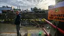Salah satu sisi jembatan Kuta Blang runtuh akibat banjir bandang yang menerjang wilayah tersebut pada Kamis 27 November 2025 sore hari. Tampak dalam foto, seorang pria menyaksikan dari jembatan yang runtuh di atas Sungai Peusangan di Kuta Blang, Kabupaten Bireuen, Provinsi Aceh, Selasa 9 Desember 2025. (CHAIDEER MAHYUDDIN/AFP)