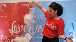 Sigi Wimala membuang sampah plastik saat acara Tempo Scan Love Earth, Jakarta, Kamis (28/4). Melalui Program Tempo Scan Love Earth, konsumen didorong untuk menggunakan tas ramah lingkungan. (Liputan6.com/Gempur M Surya)