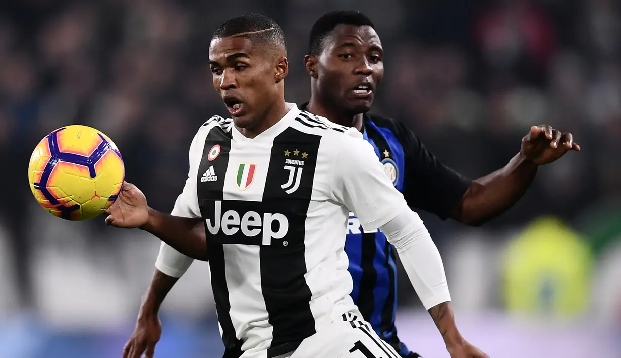 Gelandang Juventus, Douglas Costa mengontrol bola dari kawalan bek Inter Milan, Kwadwo Asamoah selama pertandingan lanjutan Liga Serie A Italia di Allianz stadium, Turin (7/12). Juventus menang tipis atas Inter Milan 1-0. (AFP Photo/Marco Bertorello)