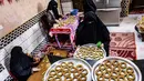 Kesibukan anggota keluarga Palestina menyiapkan kue-kue tradisional untuk dijual sebagai persiapan liburan Idul Fitri mendatang, di kota Rafah, Jalur Gaza, Selasa (4/5/2021). Pembuatan kue tradisional untuk Hari Raya Idul Fitri atau Lebaran yang menandai akhir bulan Ramadhan. (KATA KHATIB/AFP)