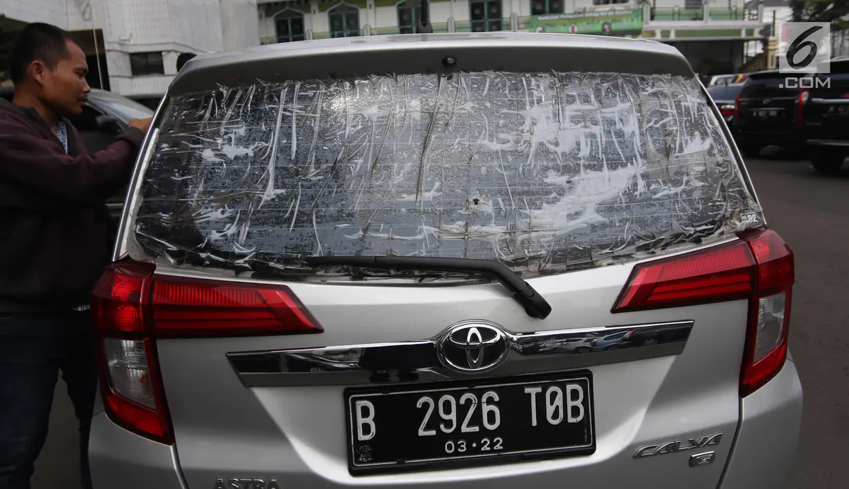 Mobil pelaku dengan kaca pecah diperlihatkan di Polres Metro Jakarta Selatan, Jumat (23/2). Para pelaku ini akan dijerat Pasal 365 KUHP tentang pencurian dengan kekerasan, dengan ancaman penjara 12 tahun. (Liputan6.com/Arya Manggala)