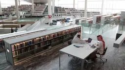 Dua pria berdiskusi saat mengunjungi Perpustakaan Nasional Qatar di ibu kota Doha pada 19 Mei 2019. Dengan lebih dari 1 juta buku cetak dan 500 ribu edisi digital, perpustakaan ini merupakan yang terbesar di Timur Tengah. (KARIM JAAFAR / AFP)