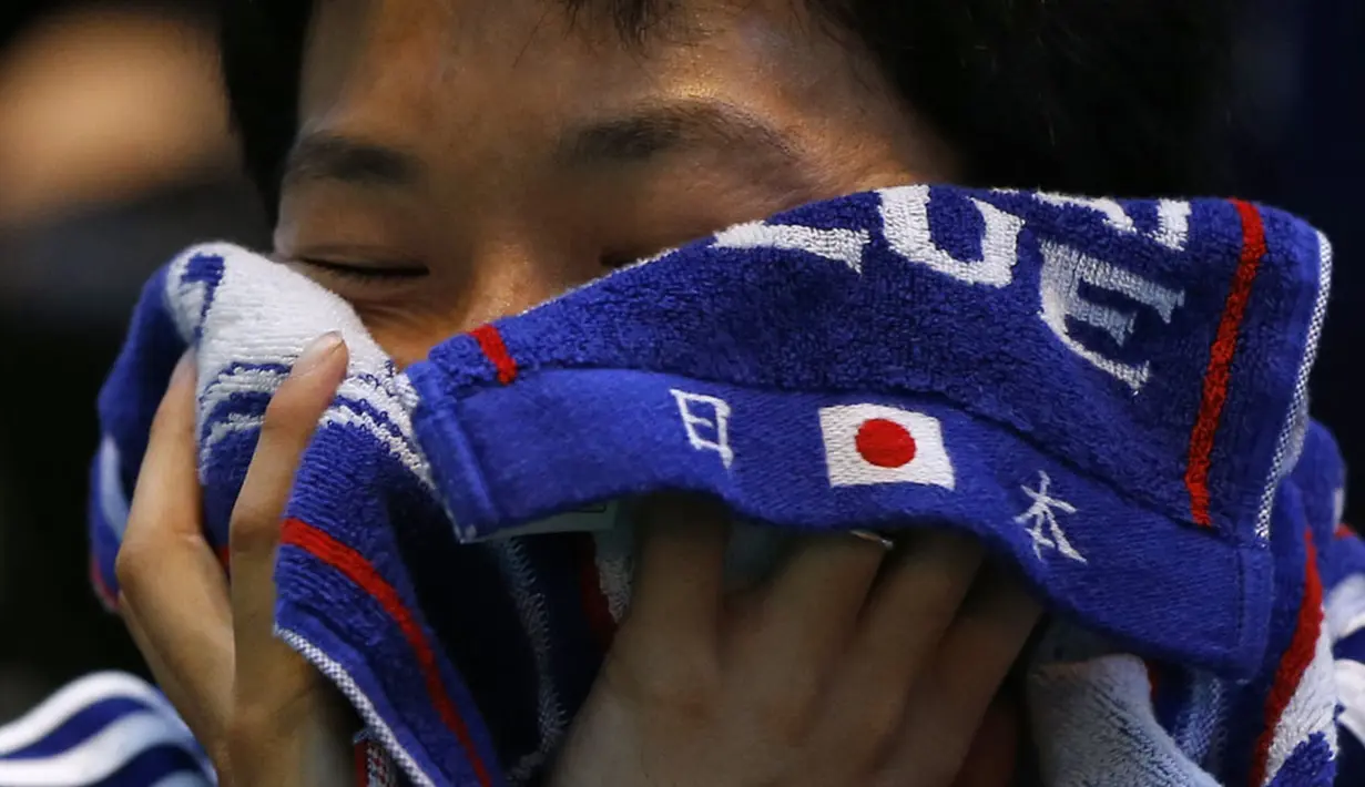 Reaksi salah satu suporter Samurai Biru yang menyaksikan kekalahan Jepang di laga penutup penyisihan Piala Dunia 2014 Grup C, (25/6/2014). (REUTERS/Issei Kato) 