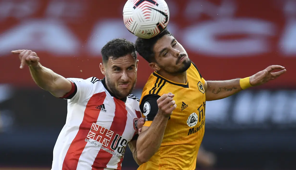 Pemain Sheffield United, George Baldock berebut bola dengan pemain Wolverhampton Wanderers, Pedro Neto  pada pertandingan Liga Inggris di stadion Bramall Lane, Inggris, Senin, (14/9/2020). Wolves menang 2-0 atas Sheffield United. (Peter Powell/Pool via AP)