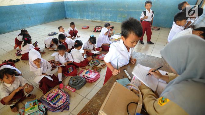 Sejumlah murid kelas II melakukan kegiatan belajar di lantai kelas SDN Kertajaya 2, Rumpin, Bogor, Senin (3/9). Tidak tersedianya meja dan kursi di tiga ruang kelas menyebabkan mereka belajar di lantai selama lebih dari 3 tahun. (Merdeka.com/Arie Basuki)
