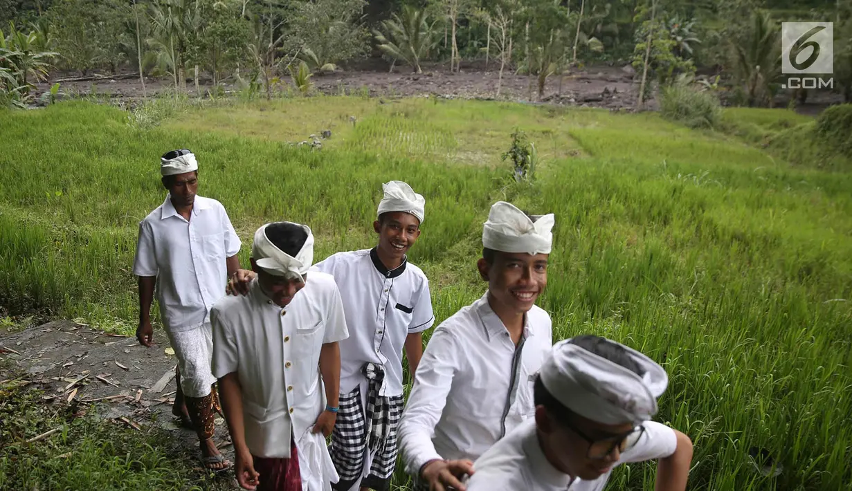 Warga berjalan untuk beribadah di sekitar Sungai Yeh Sah, Desa Batusesa, Kec Rendang, Karangasem, Bali, Jumat (1/12). Warga berharap diberi keselamatan dan berkah dari erupsi Gunung Agung yang terjadi. (Liputan6.com/Immanuel Antonius)