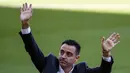 Pelatih baru Barcelona Xavi Hernandez melambai ke penonton saat presentasi resminya di stadion Camp Nou, Spanyol, Senin (8/11/2021). Barcelona menyatakan telah mencapai kesepakatan dengan Xavi dan klub yang ia tangani sebelumnya, Al-Sadd. (AP Photo/Joan Monfort)