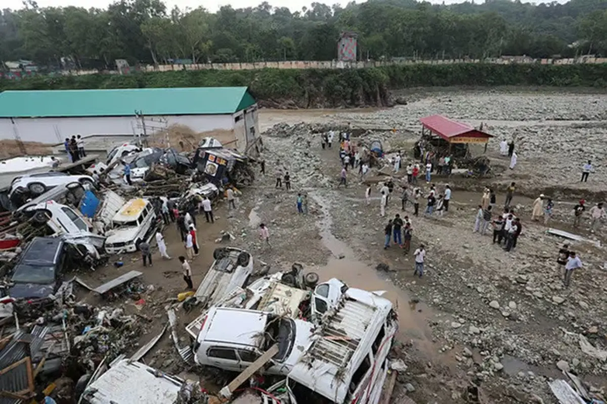 Warga melihat kendaraan yang rusak setelah banjir bandang dan tanah longsor akibat hujan deras melanda Distrik Rajouri di wilayah Jammu, India, pada Minggu (19/7/2026).