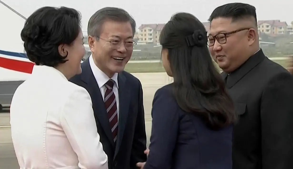 Gambar dari video yang disediakan oleh KBS, Presiden Korea Selatan, Moon Jae-in dan istrinya Kim Jung-sook disambut oleh pemimpin Korea Utara, Kim Jong-un dan sang istri, Ri Sol Ju setibanya di Pyongyang, Selasa (18/8). (Korea Broadcasting System via AP)