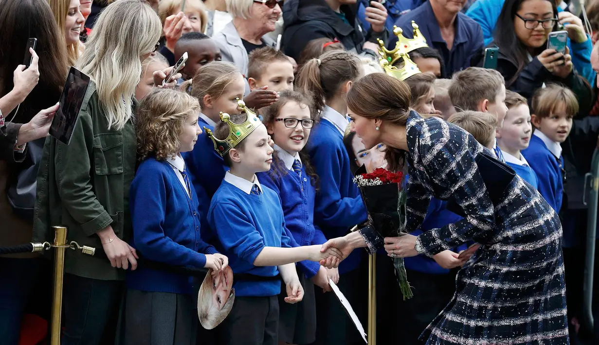 Kate Middleton bersalaman dengan salah seorang siswa dari sekolah St Philip dalam kunjungan ke Museum Nasional Sepakbola di Manchester, Inggris, (14/10). Kate tampil cantik didampingi suaminya Pangeran Wiliam. (Reuters/Phil Noble)