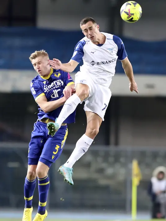 Bek Lazio Adam Marusic berebut bola dengan bek Hellas Verona Josh Doig  dalam laga pekan ke-21 Serie A di Stadio Marc'Antonio Bentegodi, Selasa (7/02/2023). Adapun pencetak gol dari Verona di menit ke 51 melalui Cyril Ngonge. (Paola Garbuio/LaPresse via AP)