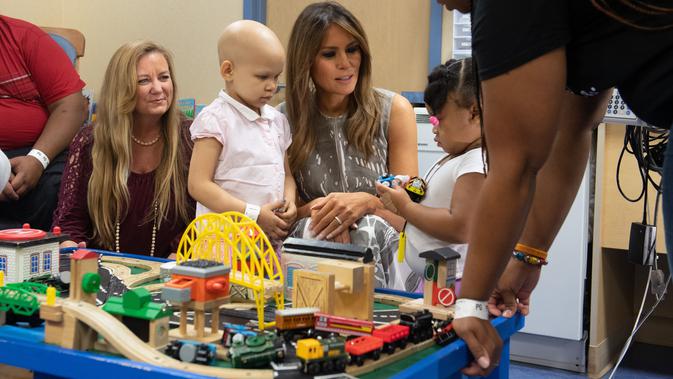 Ibu Negara AS, Melania Trump bermain dengan pasien anak, Essence dan Natalayah saat mengunjungi Rumah Sakit Anak Monroe Carell Jr. di Nashville, Selasa (24/7). Kedatangan Melania untuk berdiskusi terkait Neonatal Abstinence Syndrome (NAS). (AFP/SAUL LOEB)
