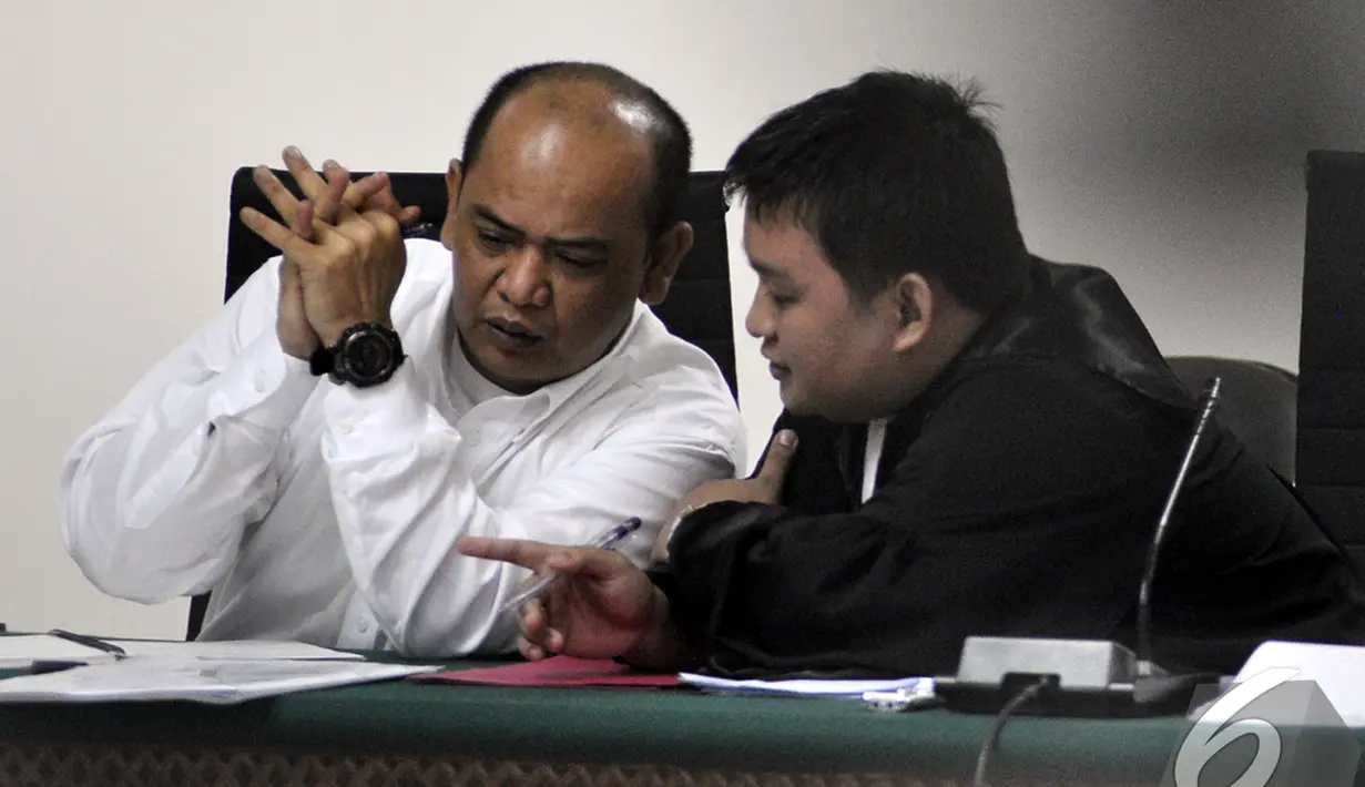 Gulat Manurung berdiskusi dengan penasehat hukumnya saat menjalani   sidang lanjutan di Pengadilan Tipikor, Jakarta, Senin (5/1/2015).   (Liputan6.com/Miftahul Hayat)