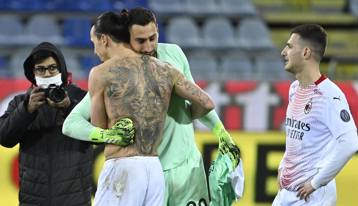 Striker AC Milan, Zlatan Ibrahimovic (kiri) memeluk kiper Gianluigi Donnarumma usai berakhirnya laga lanjutan Liga Italia 2020/21 pekan ke-18 melawan Cagliari di Sardegna Arena, Senin (18/1/2021). AC Milan menang 2-0 atas Cagliari. (AFP/Alberto Pizzoli)
