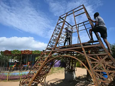 Para pekerja membangun model replika Menara Eiffel di sebuah taman di Puducherry, sebuah wilayah bekas koloni Prancis di India pada tanggal 18 Januari 2024. (Arun SANKAR/AFP)