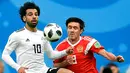 Penyerang Mesir, Mohamed Salah berusaha mengontrol bola dari kawalan pemain Rusia, Yuri Zhirkov saat bertanding pada grup A Piala Dunia 2018 di stadion St. Petersburg di St. Petersburg, (19/6). (AP Photo / Martin Meissner)