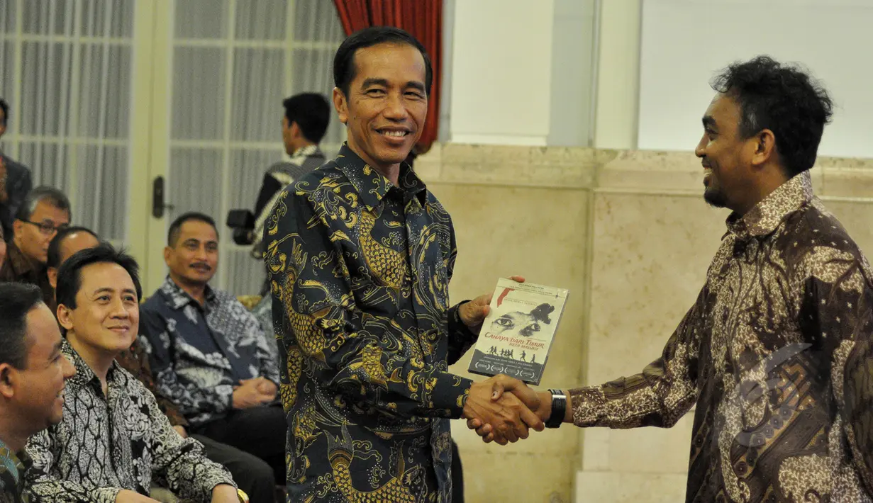 Glen Fredly memberikan DVD film Cahaya dari Timur kepada Presiden Jokowi saat peringatan Hari Film Nasional ke-65 di Istana Negara, Jakarta, Senin (30/3/2015). (Liputan6.com/Faizal Fanani)