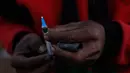 Seorang penambang bersiap menyuntikan jarum suntik berisikan heroin ke tubuhnya di Tambang batu giok di Hpakant, Myanmar, 29 November 2015. Kecanduan narkotika sudah merabak pada penambang batu giok. (REUTERS/Soe Zeya Tun)