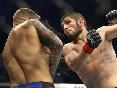 Khabib Nurmagomedov (kanan) meninju Dustin Poirier dalam pertarungan UFC 242 di Mal Yas di Abu Dhabi, Uni Emirat Arab (7/9/2019).  Khabib menang di ronde ketiga dengan cara submission. (AP Photo/ Mahmoud Khaled)