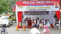 Warga yang hendak berlibur menunggu untuk rapid test antigen yang disediakan oleh Dinas Kesehatan dan Petugas Gabungan dari unsur TNI, Polri dan Satpol PP Provinsi Jawa Barat di Rest Area KM 57, Tol Jakarta-Cikampek, Karawang, Jawa Barat, Kamis (24/12/2020). (Liputan6.com/Herman Zakharia)