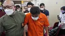Petugas imigrasi mengawal Mitsuhiro Taniguchi (47) usai konferensi pers di Kantor Imigrasi, Jakarta, Indonesia, Rabu (8/6/2022). "MT (Mitsuhiro Taniguchi) sudah diamankan oleh pihak imigrasi setelah pihak Jepang mencabut passport yang bersangkutan," kata Kepala Divisi Humas Polri Irjen Dedi Prasetyo kepada wartawan, Rabu (8/6/2022). (AP Photo/Achmad Ibrahim)