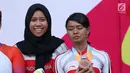 Atlet ParaCycling, Ni Mal Maghfiroh (kiri) dan Sri Sugiyanti saat prosesi pengalungan medali nomor Womens B Individual Time Trial Road Race Asian Para Games 2018 di Sirkuit Sentul, Bogor, Senin (8/10). (Liputan6.com/Helmi Fithriansyah)