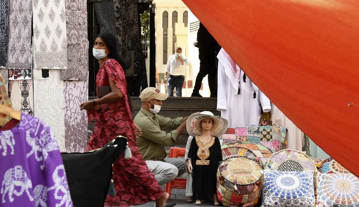 Seorang wanita mengenakan masker berjalan di Deira Souk di Teluk Emirat Dubai (30/9/2020). Barang yang dijual di Deira Souk juga paling diminati turis seperti rempah dan emas. (AFP/Karim Sahib)