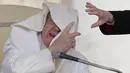 Paus Fransiskus saat memberikan ceramah di hadapan publik di alun-alun Santo Petrus, Vatikan (26/4). Tiupan angin membuat wajah Paus Fransiskus tertutup jubah yang ia kenakan. (AP Photo / Andrew Medichini)