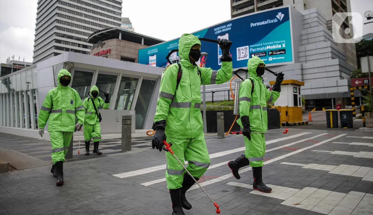 Petugas menyemprotkan cairan disinfektan di ruang publik kawasan pedestrian Sudirman, Jakarta, Kamis (19/3/2020). Penyemprotan dilakukan untuk antisipasi dan pencegahan penyebaran COVID-19 di lingkungan ruang publik yang banyak di gunakan oleh masyarakat. (Liputan6.com/Faizal Fanani)