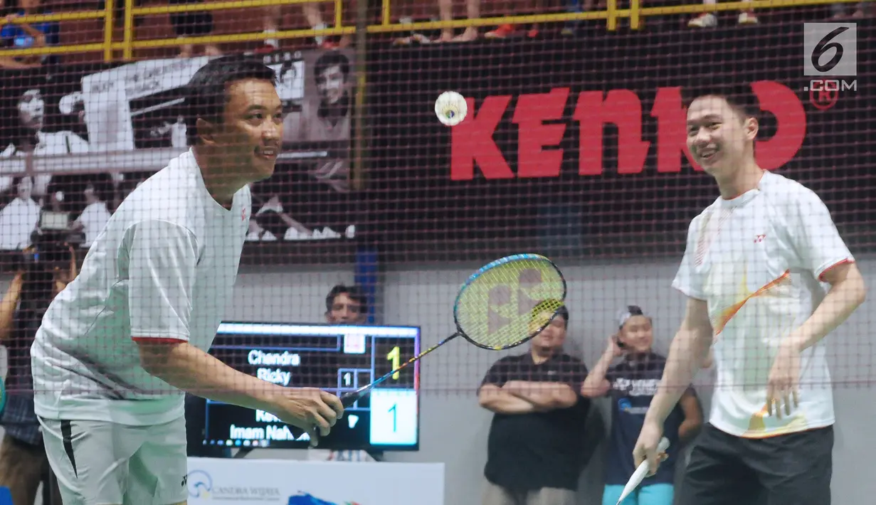 Menpora Imam Nahrawi (kiri) berpasangan dengan Kevin Sanjaya pada laga eksebisi melawan Candra Wijaya/Ricky Subagja di Candra Wijaya Internasional Badminton Centre, Tangerang Banten, Selasa (19/12). (Liputan6.com/Helmi Fithriansyah)