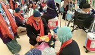 Sejumlah jemaah haji terpaksa membongkar lagi kopernya untuk mengeluarkan barang-barang yang dilarang dibawa dalam penerbangan pulang ke Tanah Air. Pembongkaran koper ini dilakukan di Terminal Haji Bandara King Abdul Aziz, Jeddah, Arab Saudi. (Liputan6.com/Dinny Mutiah)