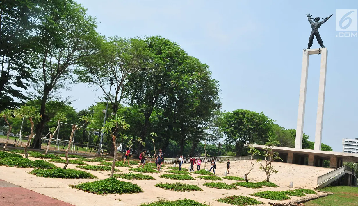 Sejumlah remaja melintasi depan Monumen Pembebasan Irian Barat, Taman Banteng, Jakarta, Sabtu (7/10). Revitalisasi Lapangan Banteng dibagi menjadi tiga segmen yakni revitalisasi taman dan patung, pagar serta lapangan olahraga. (Liputan6.com/Helmi Afandi)