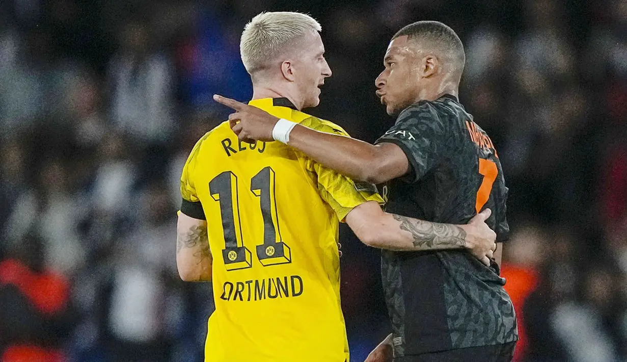 Pemain Paris Saint-Germain (PSG), Kylian Mbappe, berbincang dengan pemain Borussia Dortmund, Marco Reus, pada laga Liga Champions di Stadion Parc des Princes, Rabu (20/9/2023). PSG menang dengan skor 2-0. (AP Photo/Michel Euler)