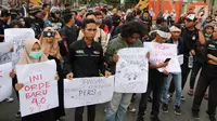 Massa yang tergabung dalam Aliansi Jurnalis Gorontalo membawa sejumlah poster saat menggelar aksi menolak RUU KUHP di Gorontalo, Senin (23/9/2019). Massa terdiri dari AJI, PWI, IJTI, dan beberapa organisasi jurnalis kampus di Gorontalo. (Liputan6.com/Arfandi Ibrahim)