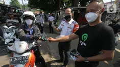 Head of Excellence Regional Operations Public Policy & Government Relations Gojek Muhammad Chairil dan Kadishub Kota Depok Dadang Wihana membagikan masker kepada pengendara dalam rangka Hari Perhubungan Nasional di Kota Depok, Jawa Barat, Jumat (18/8/2020). (Liputan6.com/HO/Ading)