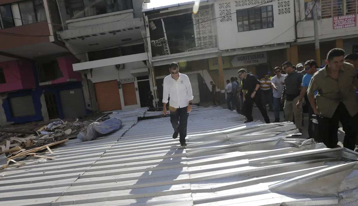 Presiden Ekuador, Rafael Correa berjalan di puing-puing bangunan yang hancur akibat gempa di Portoviejo, Ekuador, 18 April 2016. Dalam kesempatan tersebut, Rafael berbincang dengan warga yang menjadi korban gempa berkekuatan 7,8 SR. (REUTERS/Henry Romero)