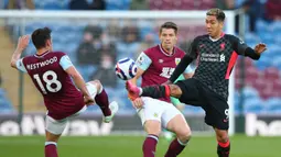 Gelandang Liverpool, Roberto Firmino (kanan) berebut bola dengan gelandang Burnley, Ashley Westwood dalam laga lanjutan Liga Inggris 2020/2021 pekan ke-37 di Turf Moor, Burnley, Rabu (19/5/2021). Liverpool menang 3-0 atas Burnley. (AFP/Alex Livesey/Pool)