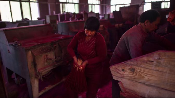 Gambar pada 11 Desember 2019 menunjukkan pekerja membuat dupa di di Pabrik Dupa Fujian Xingquan, Provinsi Fujian, China. Penduduk setempat mengklaim satu dari setiap tiga batang dupa yang dijual di Asia Tenggara dibuat di Yongchun, daerah pegunungan di Provinsi Fujian tenggara. (HECTOR RETAMAL/AFP)