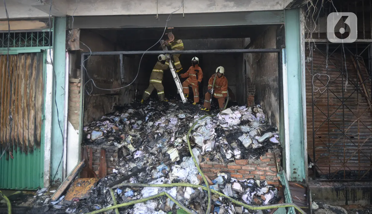 Petugas pemadam kebakaran melakukan pembasahan bioskop Grand Theater yang terbakar di Simpang Lima Senen, Jakarta, Jumat (9/10/2020). Unjuk rasa menentang disahkannya Omnibus Law UU Cipta Kerja berujung aksi anarkis merusak berbagai fasilitas umum pada Kamis malam (8/10). (merdeka.com/Dwi Narwoko)