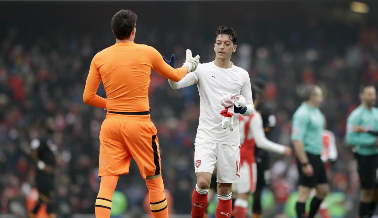 Pemain Arsenal, Mesut Ozil (kanan) bertukar jersey dengan pemain Hull City, Eldin Jakupovic pada lanjutan Premier League di Emirates Stadium, London, (11/2/2017). Arsenal menang 2-0.  (AP/Matt Dunham)