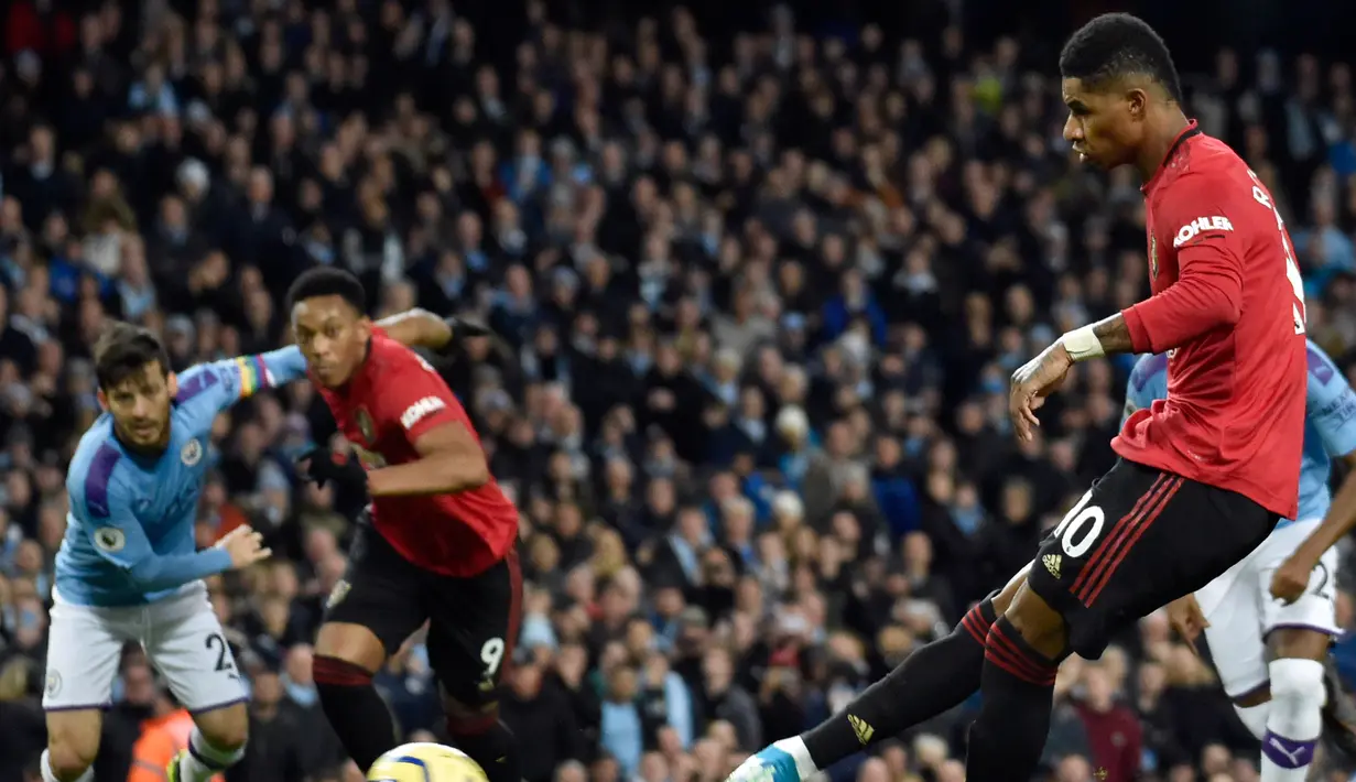 Pemain Manchester United Marcus Rashford (kanan) mencetak gol ke gawang Manchester City pada pertandingan Liga Inggris di Etihad Stadium, Manchester, Inggris, Sabtu (7/12/2019). Manchester United menang 2-1. (AP Photo/Rui Vieira)